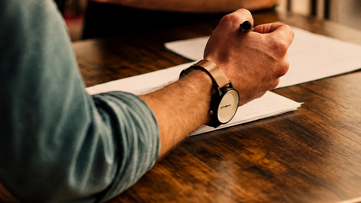 Businessperson taking notes during meeting