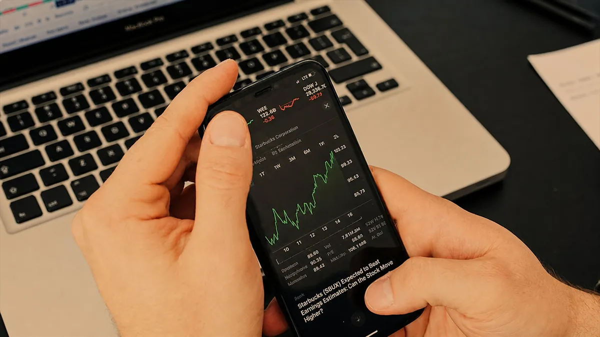 Investor checking stock market app on phone