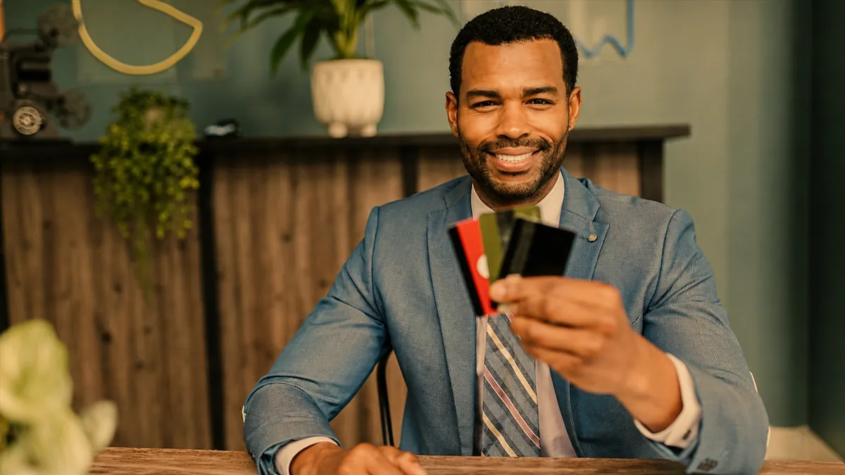 Man comparing credit cards at home